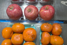 熟した柿とリンゴの箱詰め